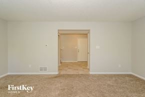 Indianapolis house for rent - A carpeted room with a doorway leading to another room.