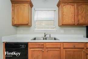 Indianapolis house for rent - A kitchen with wooden cabinets and a sink under a window.