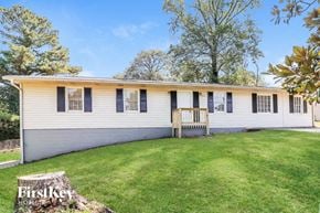 Marietta house for rent - a white house with a green lawn and a porch