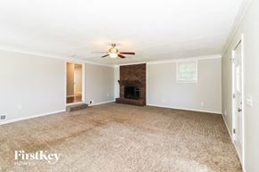 Marietta house for rent - a living room with a fireplace and a ceiling fan