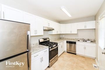 Marietta house for rent - a kitchen with stainless steel appliances and white cabinets