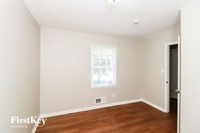Marietta house for rent - a bedroom with white walls and a window and wood floors