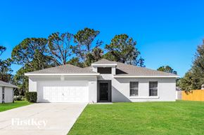 North Port house for rent - a white house with a lawn and a garage door