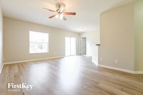 North Port house for rent - an empty living room with wood floors and a ceiling fan