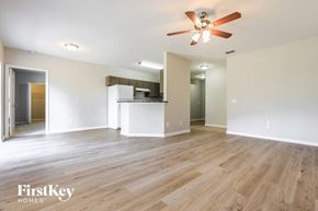 North Port house for rent - an empty living room with wood flooring and a ceiling fan