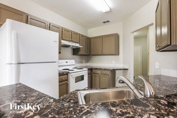 North Port house for rent - a kitchen with white appliances and granite counter tops