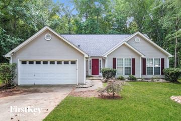 Gainesville house for rent - a home with a red door and a white house with a lawn and trees
