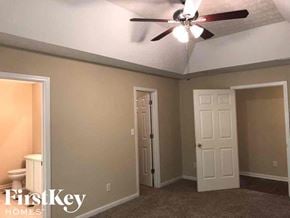 Gainesville house for rent - a bedroom with a ceiling fan and a door to the bathroom