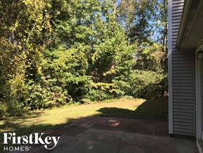 Gainesville house for rent - the backyard of a house with grass and trees