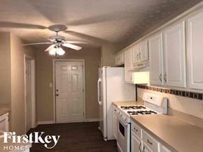 Gainesville house for rent - a kitchen with white cabinets and a ceiling fan