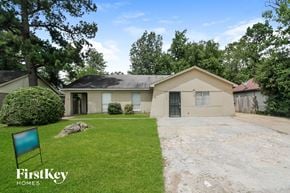 Memphis house for rent - a small tan house with a lawn and a driveway