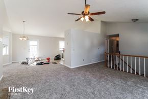Powder Springs house for rent - A spacious room with a ceiling fan and a carpeted floor.