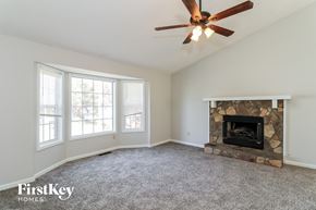 Powder Springs house for rent - A room with a fireplace and a ceiling fan.