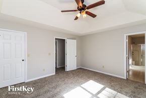 Powder Springs house for rent - A room with a ceiling fan and a carpeted floor.