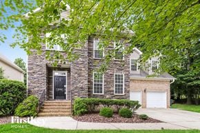 Greensboro house for rent - A house with a black front door and a garage door.