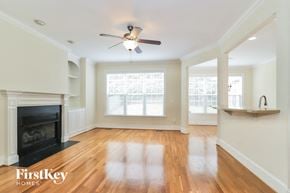 Greensboro house for rent - A spacious living room with wood floors and a fireplace.