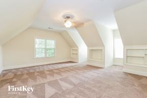 Greensboro house for rent - A room with a carpeted floor and a window with a view of trees.