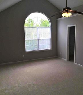 Douglasville house for rent - an empty bedroom with a large window and a ceiling fan
