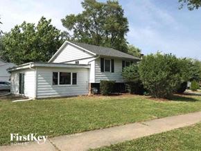 Richton Park house for rent - A white house with a grey roof and a green lawn in front.