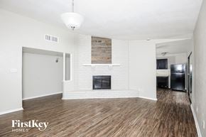 Fort Worth house for rent - A living room with a fireplace and wood flooring.