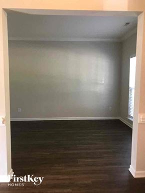 Winston-Salem house for rent - an empty living room with wood floors and white walls