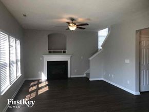 Winston-Salem house for rent - a living room with a fireplace and a ceiling fan