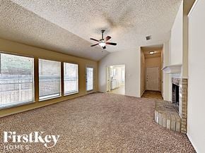 Fort Worth house for rent - A spacious room with a fireplace and a ceiling fan.