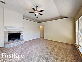 Fort Worth house for rent - A room with a fireplace and a ceiling fan.