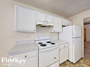 Fort Worth house for rent - A kitchen with white appliances and cabinets.