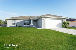 Lehigh Acres house for rent - A house with a garage and a lawn in front.