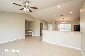 Lehigh Acres house for rent - A spacious living room with a ceiling fan and tiled flooring.