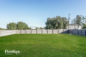 Lehigh Acres house for rent - A grassy field with a fence and trees in the background.