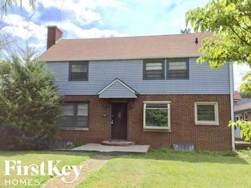 Indianapolis house for rent - a brick house with a blue roof and a front porch