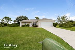 Lehigh Acres house for rent - A house with a green lawn and a garage door.
