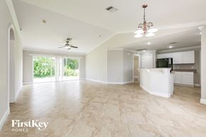 Lehigh Acres house for rent - A spacious living room with a kitchen in the background.