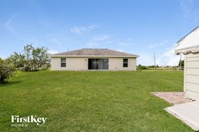 Lehigh Acres house for rent - A white house with a grassy lawn in front of it.
