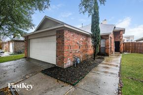 Mesquite house for rent - a brick house with a white garage door and a sidewalk
