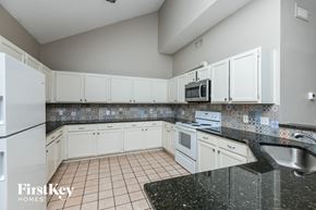 Mesquite house for rent - a kitchen with white cabinets and granite counter tops