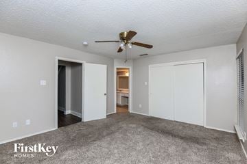 Mesquite house for rent - a living room with carpet and a ceiling fan