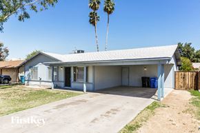 Phoenix house for rent - a blue and white house with a driveway and palm trees