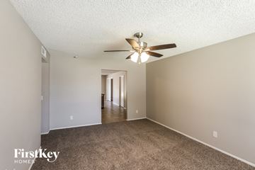 Phoenix house for rent - a spacious living room with carpet and a ceiling fan