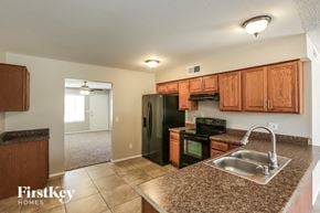 Phoenix house for rent - a kitchen with black appliances and granite counter tops
