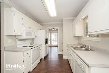 Helena house for rent - A kitchen with white cabinets and appliances.