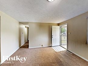 Indianapolis house for rent - A carpeted room with a door and a window.