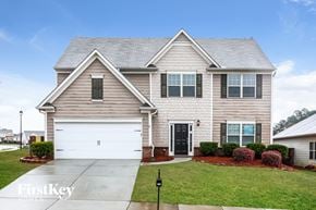 Gainesville house for rent - a beige house with a white garage door in front of a green lawn