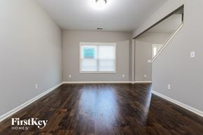 Gainesville house for rent - the living room of an empty house with wood floors and a window