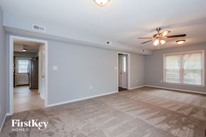 Charlotte house for rent - A spacious room with a carpeted floor and a ceiling fan.