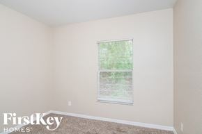 North Port house for rent - a bedroom with beige carpet and a window with blinds