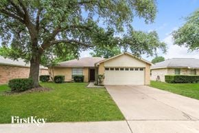 Katy house for rent - a home with a garage and a tree in the yard