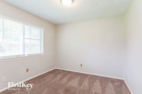 Katy house for rent - a bedroom with a carpeted floor and a large window